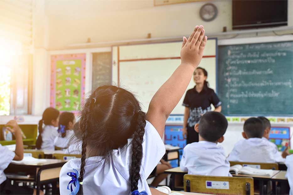 Kids in a classroom with teacher in the background at Cayman International School, Grand Cayman.