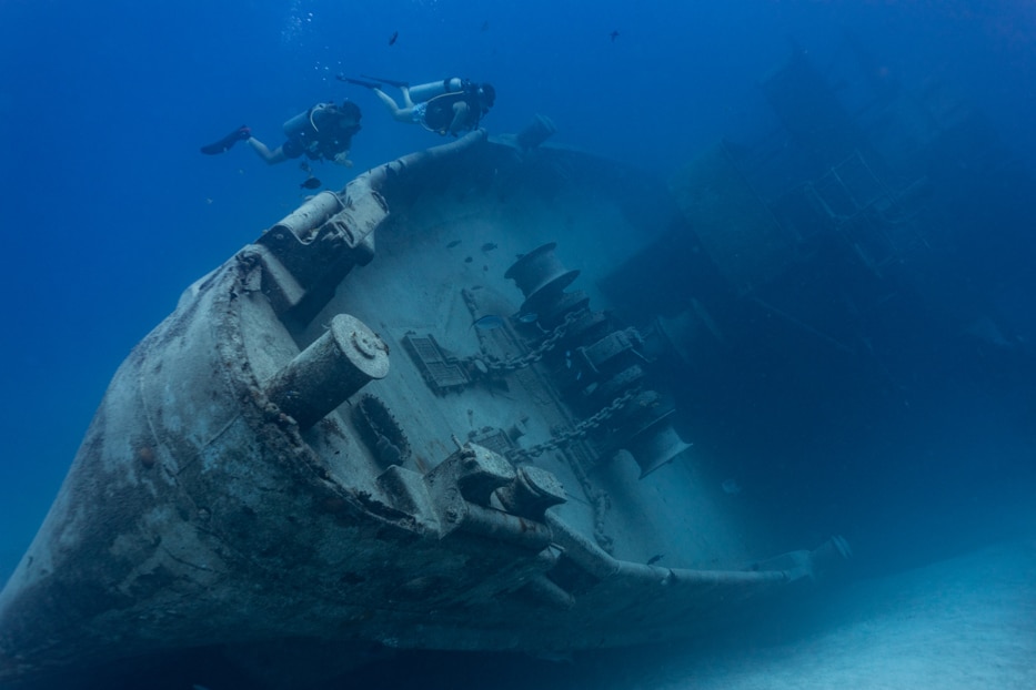 Divers exploring the USS Kittiwake located in the waters off Seven Mile Beach, Grand Cayman.