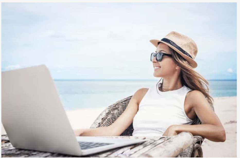 Lady working remotely on the beach in the Cayman Islands