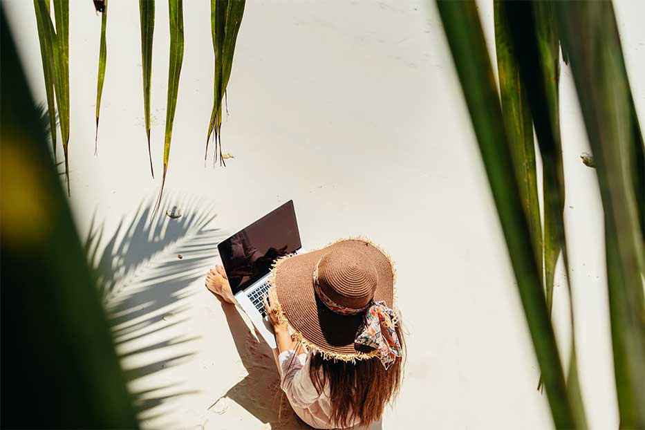 Woman with laptop working on beach Grand Cayman