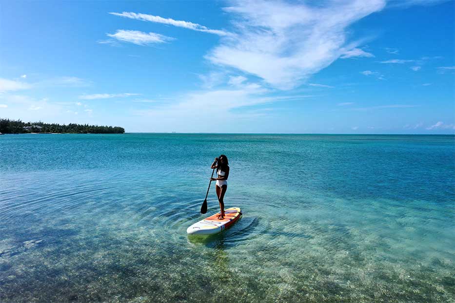 Woman paddle boarding in the Cayman Islands