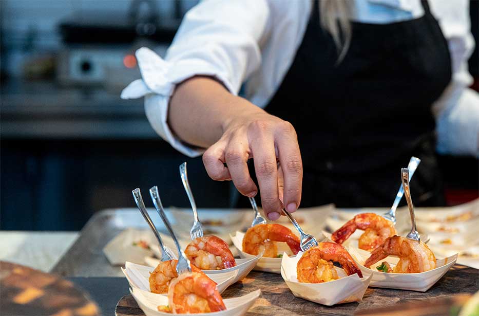 A chef plating a shrimp hors d'oeuvres in Grand Cayman