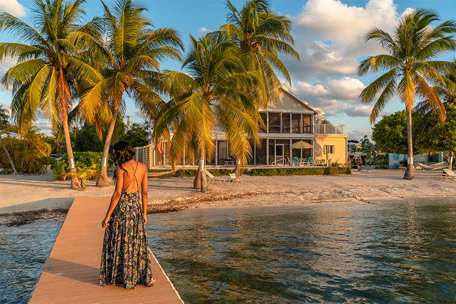 Woman standing on a dock in front of a home in the Cayman Islands