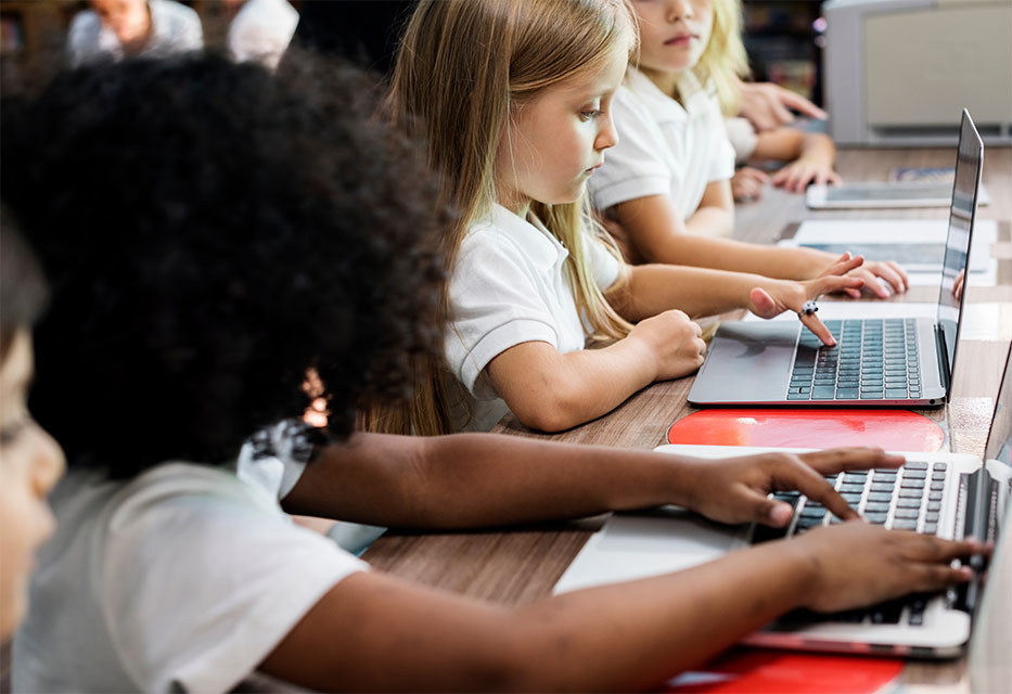 Children learning in computers in a school classroom